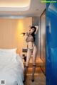 A woman in lingerie posing on a bed in a hotel room.