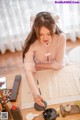 A woman sitting at a table writing on a piece of paper.