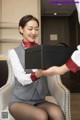 A woman sitting in a chair holding a box.