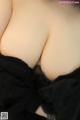 A close up of a woman's breasts in a black dress.