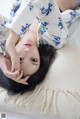 A woman laying on top of a white pillow.