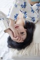 A woman laying on top of a white pillow.