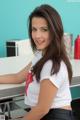 A woman sitting at a counter in a white shirt.