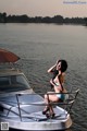 A woman in a bikini sitting on a boat.