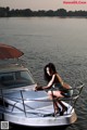 A woman in a bikini sitting on a boat.