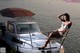 A woman in a blue bikini sitting on a boat.