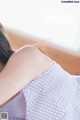 A woman laying on a bed with her back to the camera.