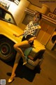 A woman sitting on top of a yellow car.