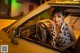 A woman sitting in the driver's seat of a yellow car.