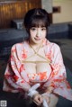 A woman in a pink kimono is tied up with a rope.