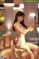 A woman in a gold dress taking a selfie.