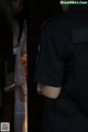 A woman in a police uniform standing in front of a door.