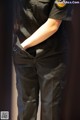 A woman in a police uniform is standing with her hands in her pockets.