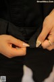 A woman wearing a black shirt and a gold ring.