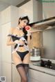 A woman in lingerie holding an apple in a kitchen.