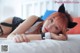 A woman laying on a bed wearing a cat ears headband.